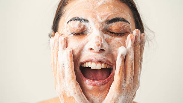 istock Beautiful woman washing her face 2211214225