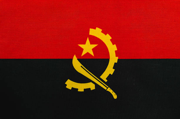 A vibrant flag of Angola featuring red, black, and yellow colors is prominently displayed at a cultural event, symbolizing national pride and heritage.