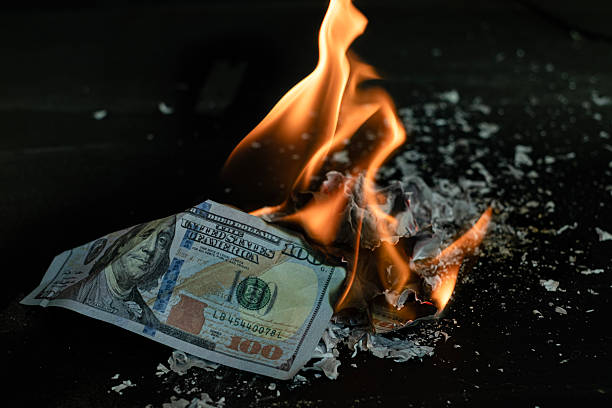istock Stack banknote is burning on a black background, symbolizing business payment and financial success 2211215284