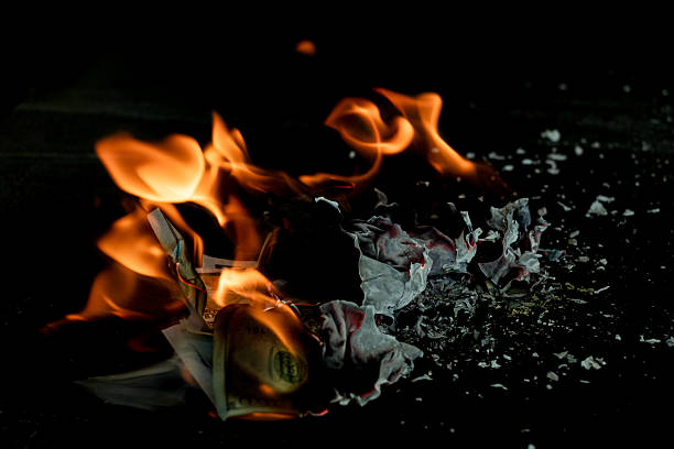 istock Stack banknote is burning on a black background, symbolizing business payment and financial success 2211215285