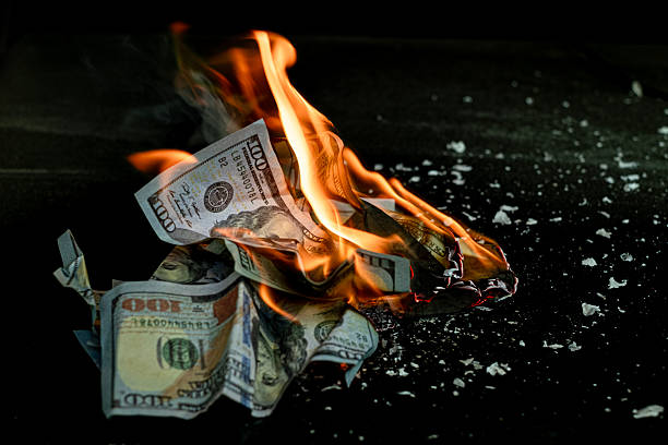 istock Stack banknote is burning on a black background, symbolizing business payment and financial success 2211215286