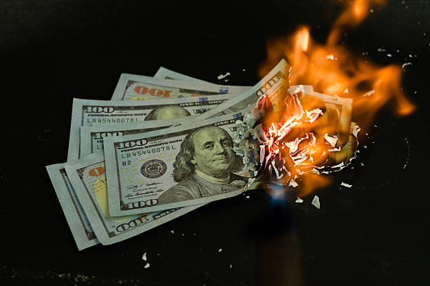 istock Stack banknote is burning on a black background, symbolizing business payment and financial success 2211215287
