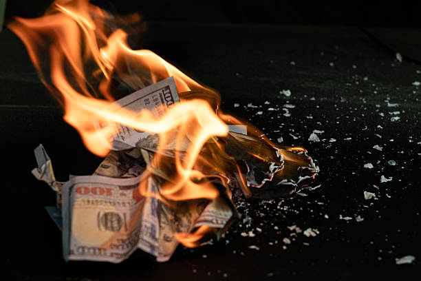 istock Stack banknote is burning on a black background, symbolizing business payment and financial success 2211215293