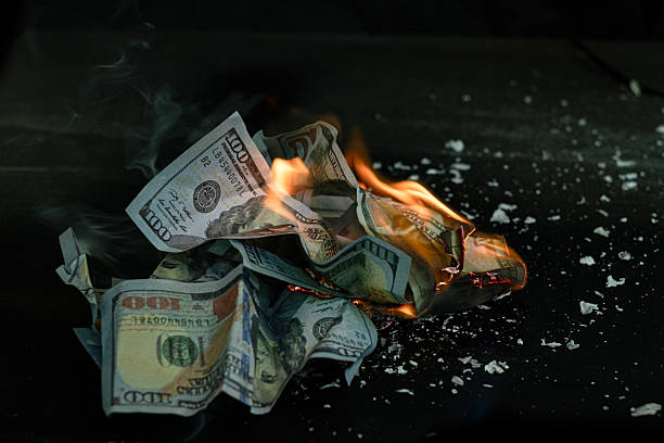 istock Stack banknote is burning on a black background, symbolizing business payment and financial success 2211215294