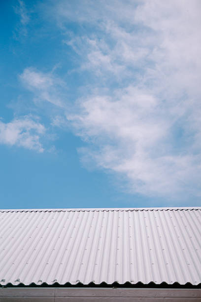 istock Crisp corrugated rooftop against a bright blue sky with soft clouds 2211215738