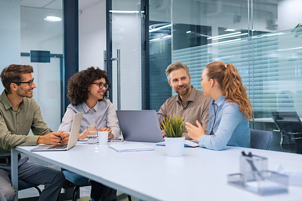 istock Business people discussing work together using a tablet and laptop taking notes in a modern office 2211217427