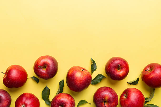 istock Many red apples on colored background, top view. Autumn pattern with fresh apple above view with copy space for design or text 2211217452