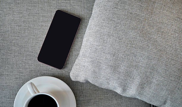 istock Flat Lay, Top view smartphone mockup and  a cup of black coffee on fabric textile with copy space, digital NOMAD, freelancer workplace or online shopping concept 2211218755