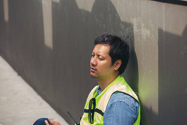 istock Worker, Construction site area. Worker tired and thirst of water at construction site. Construction builder worker sitting and feel sick, have a headache. Health safe of work and safety first concept 2211222195