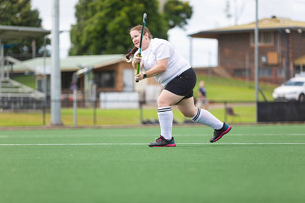 istock Middle aged woman practicing field hockey 2211225845