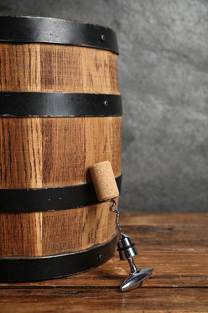 istock Corkscrew with metal handle, cork and wooden barrel on table 2211225923