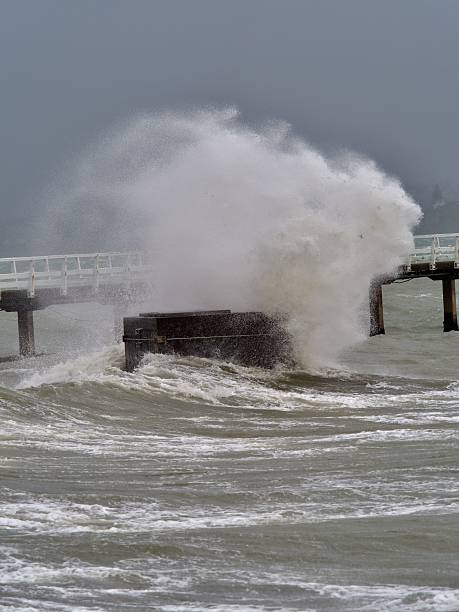 istock Dramatic ocean waves crashing against a pier. 2211226442
