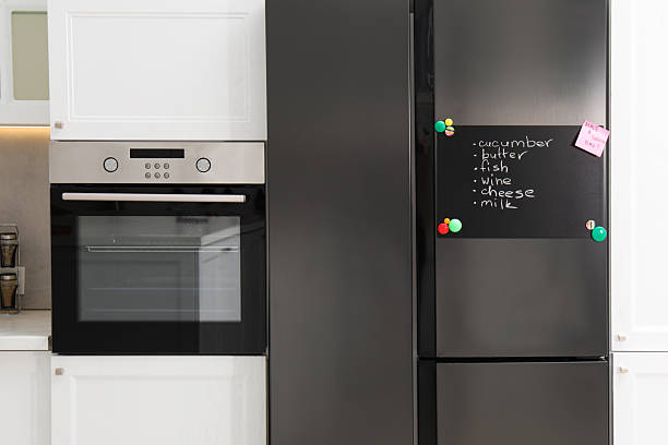 istock Magnetic board with shopping list and note on refrigerator in kitchen 2211227278
