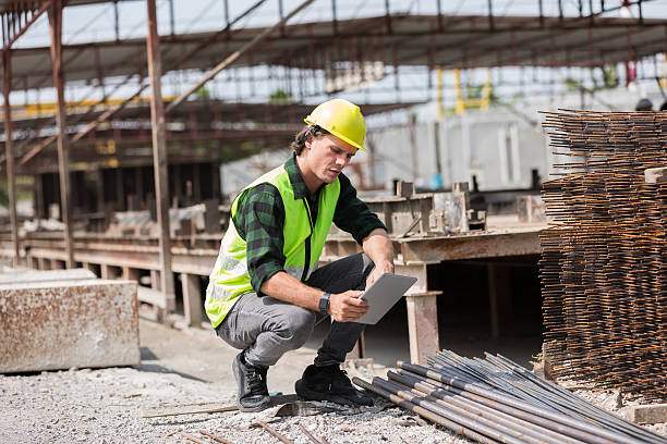 istock Engineer, Construction site. Foreman builder man working and inspecting materials used to build precast concrete walls at construction site. Foreman construction man working at site work 2211227335