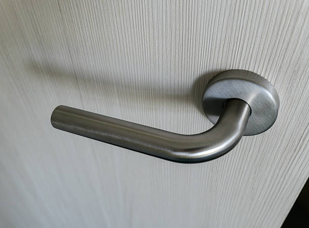 istock Stainless steel door handle on a light door close-up 2211231284
