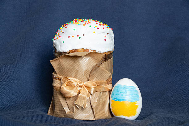 istock Easter cake and egg with Ukrainian flag standing on blue fabric, Easter 2211233526