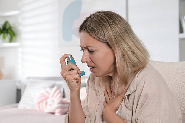 istock Woman using inhaler at home. Asthma treatment 2211235036