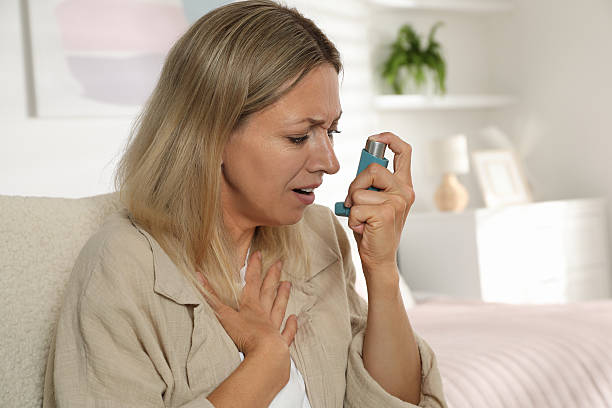 istock Woman using inhaler at home. Asthma treatment 2211235133