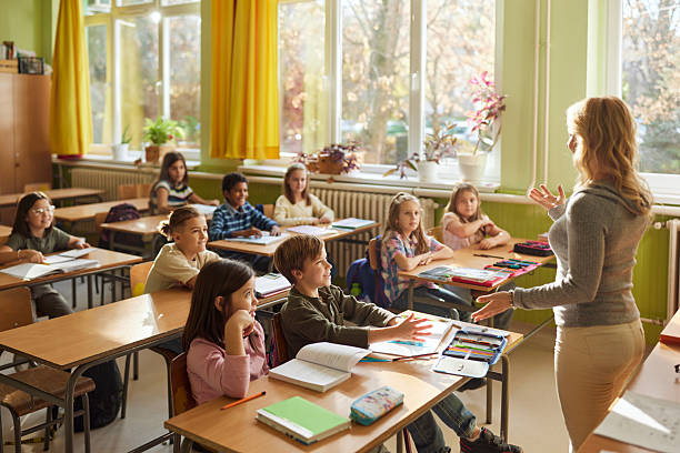 istock Happy students enjoying in lecture by their elementary teacher. 2211236542