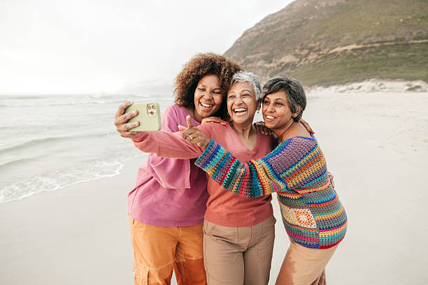 istock Women on the move: friendship and laughter by the ocean 2211237942
