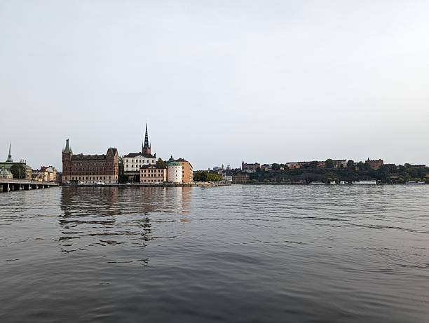 Scenic view of Stockholm's historic architecture reflected in calm waters under a clear sky.