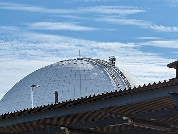 View of the iconic Avicii Arena in Stockholm under a vibrant blue sky, showcasing its unique spherical architecture.