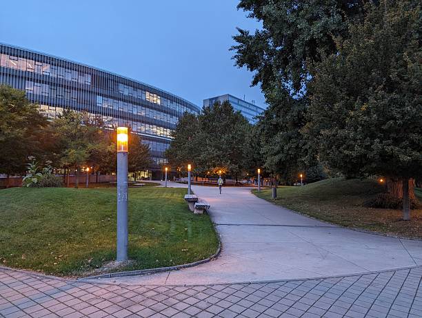 istock Modern office building with evening lights in urban park. 2211240649