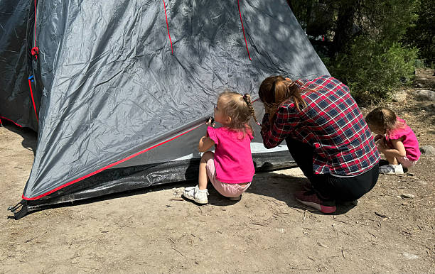 istock A mother and her twin daughters set up a tent while camping in the mountains. A heartwarming moment of family bonding, outdoor adventure, and teamwork in nature 2211243847