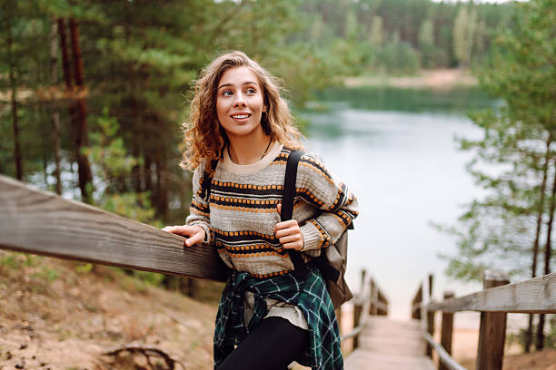 istock Young woman with backpack hiking on wooden paths in forest. 2211243853