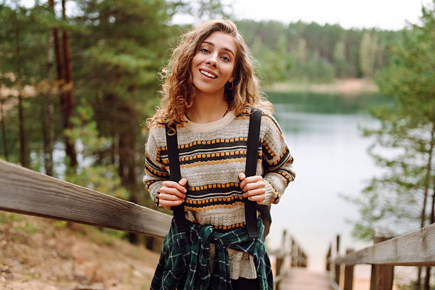 istock Young woman with backpack hiking on wooden paths in forest. 2211243857