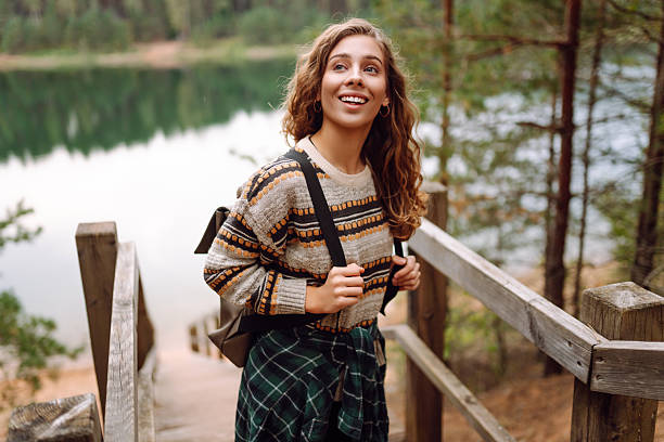 istock Young woman with backpack hiking on wooden paths in forest. 2211243877
