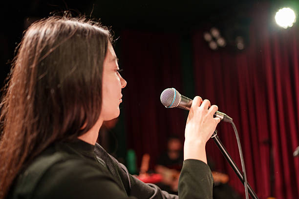 istock Vocalist Singing into Microphone During Rehearsal – Over-the-Shoulder Stage View 2211246759