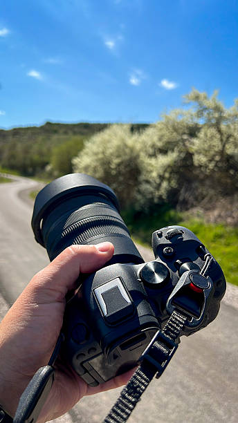 istock Photographer Holding Camera on Scenic Road 2211246782