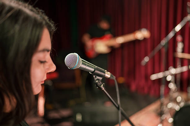istock Vocalist Singing into Microphone During Rehearsal – Over-the-Shoulder Stage View 2211246816