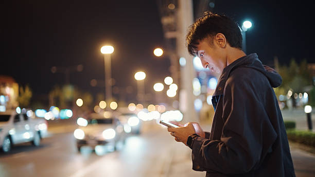 istock Man calling taxi via smartphone at night. 2211247680
