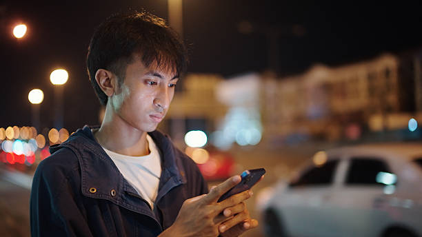 istock Man calling taxi via smartphone at night. 2211247693