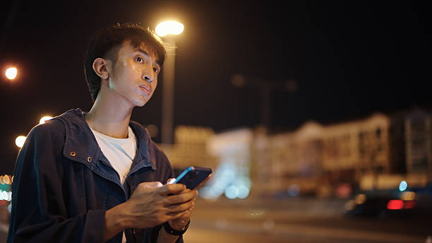 istock Man calling taxi via smartphone at night. 2211247697