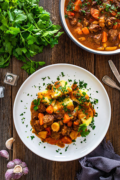 istock Beef stew with vegetables and potatoes on wooden table 2211248045
