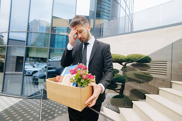 istock Sad and Shocked Man Fired From Job Standing Outside With Box 2211250595