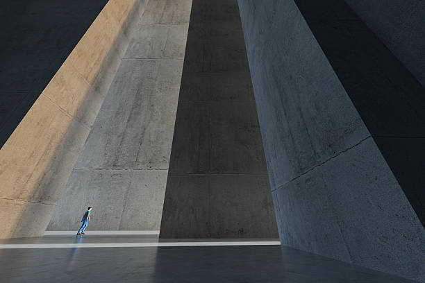 Man walking towards the light in a abstract concrete environment. Digitally Generated Image.