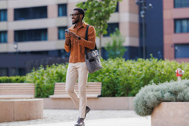 istock Businessman walking in the city and using phone 2211257201