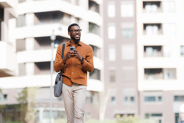 istock Smiling Black businessman walking and using phone 2211257222