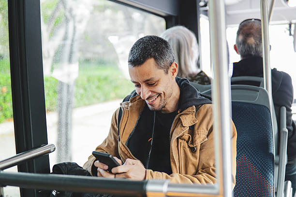 istock Man using a mobile phone or smartphone in public transport. Text messaging or using social media online. 2211257585