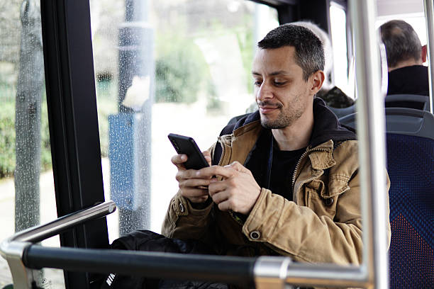 istock Man using a mobile phone or smartphone in public transport. Text messaging or using social media online. 2211257586