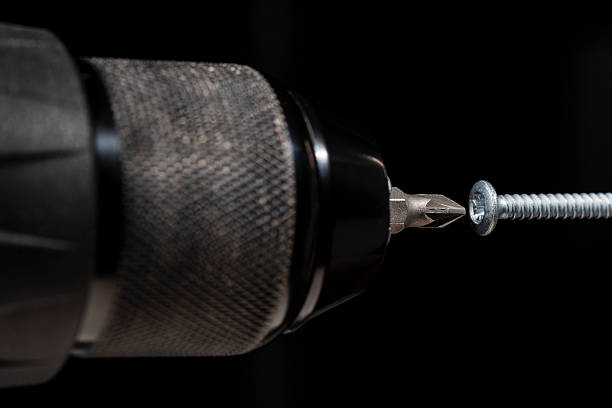 istock Chuck for cordless screwdriver with bit for unscrewing or screwing screws on black background, closeup. Nozzle for screwdriver, attachment bit, macro 2211258152