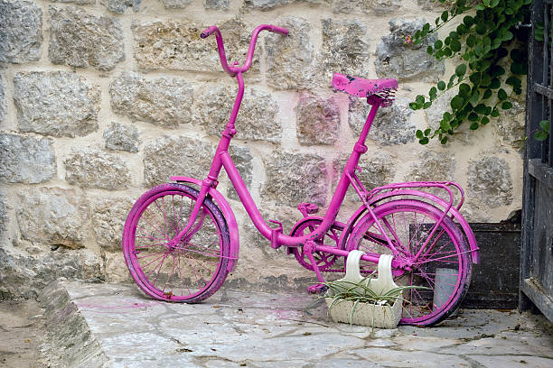 istock Pink bicycle with flowers in a basket, facade decoration 2211259551