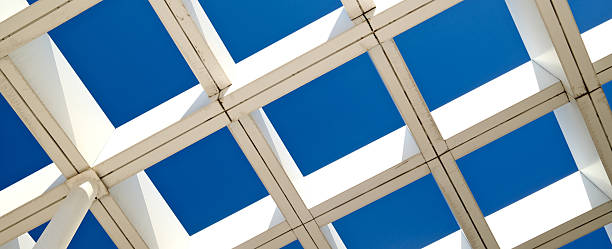 istock Striking modern architecture with geometric white pergola structure against deep blue sky. Symmetrical grid pattern and minimalist design 2211267137