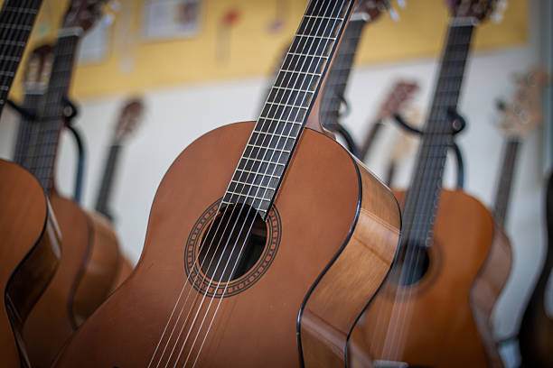 istock Classical guitars hanging in a music classroom or shop 2211267600