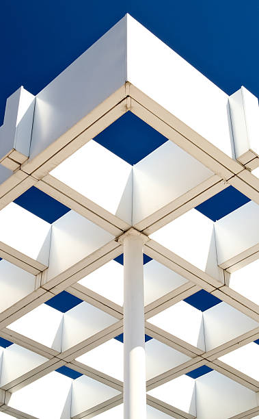 istock Striking modern architecture with geometric white pergola structure against deep blue sky. Symmetrical grid pattern and minimalist design 2211267996