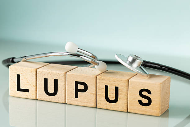 istock Lupus, Systemic Lupus Erythematosus. autoimmune disease. Immune system disorders. Medical stethoscope and word written on wooden blocks, pastel blue background, copy space 2211269385